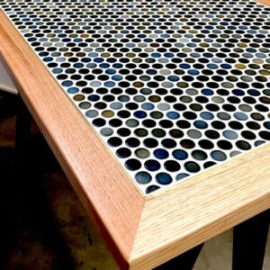 Tiled table top with penny tiles and wooden surround.