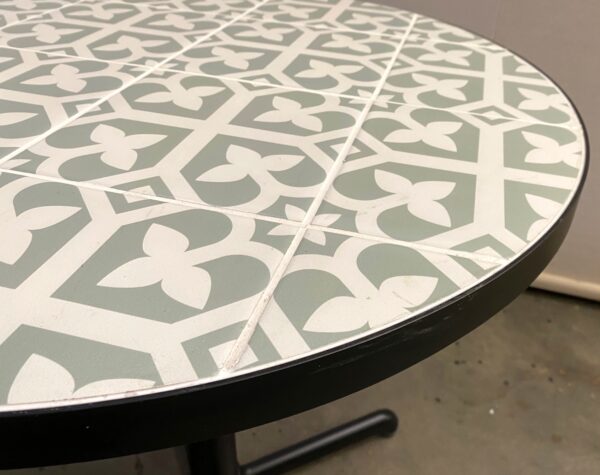 Round tile table top with steel edging.